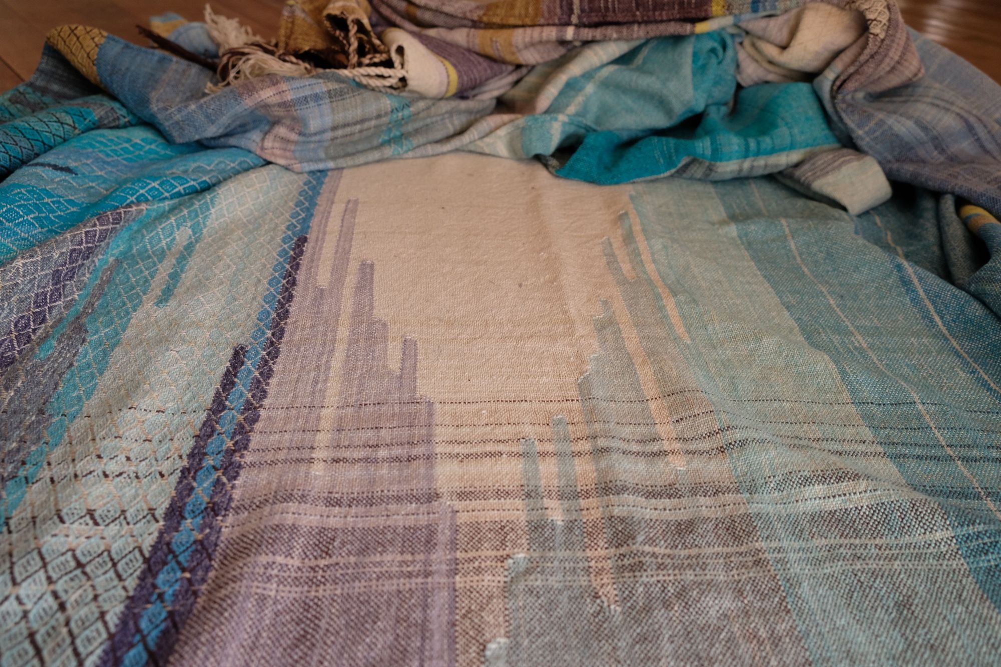 Blue and white handwoven fabric laid out on the ground