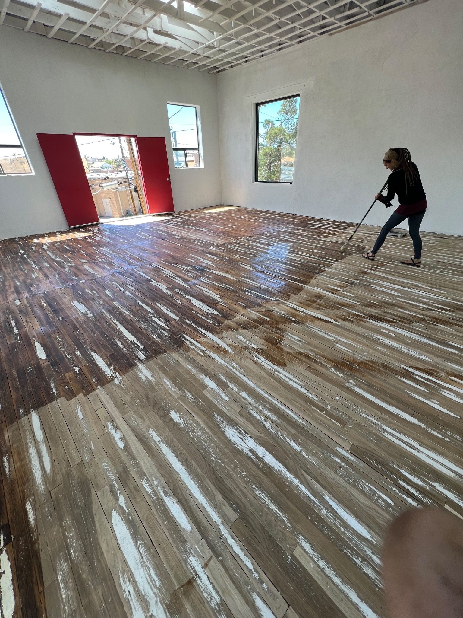 A woman oils a wood floor. 