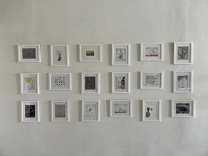 18 framed works by Jeannie Ortiz and Kyle Parker Cunningham hang on a gallery wall.