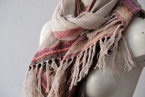 A hand woven diamond pattern, pink and cream scarf