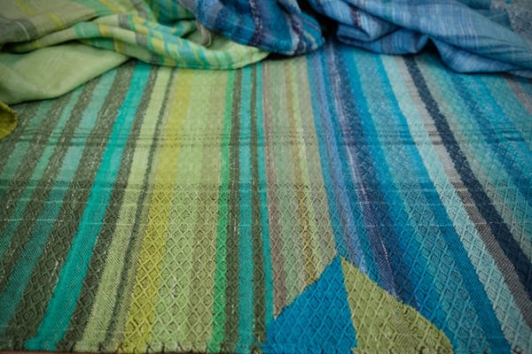 a detail of the pyramid tapestry woven detail in the middle of 5 meters of handwoven fabric in textured stripes of greens on one side and shades of blue on the other